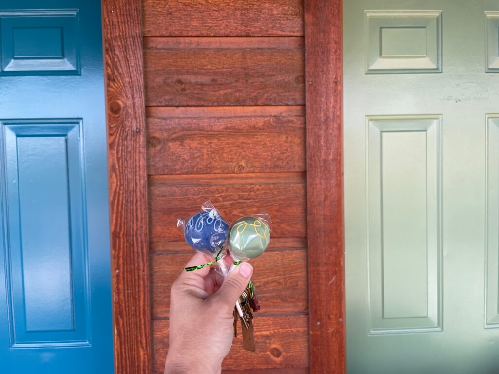 A person holding toffee in front of a wooden door